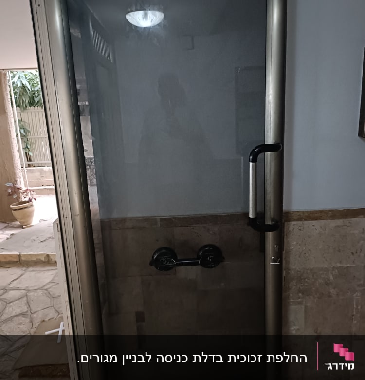 דלת זכוכית עם מסגרת מתכת וידית שחורה